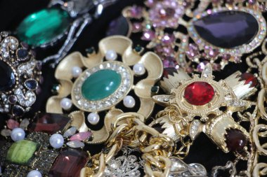 Zümrüt değerli taşlı klasik broşürler. Farklı renklerde cam ve metal broşlar. Renkli ve moda broşları. Lüks bir geçmişi var. Seçici odak