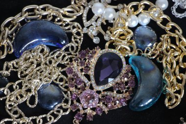 Zümrüt değerli taşlı klasik broşürler. Farklı renklerde cam ve metal broşlar. Renkli ve moda broşları. Lüks bir geçmişi var. Seçici odak