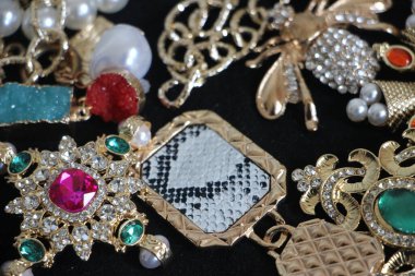 Zümrüt değerli taşlı klasik broşürler. Farklı renklerde cam ve metal broşlar. Renkli ve moda broşları. Lüks bir geçmişi var. Seçici odak