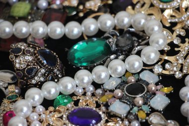 Zümrüt değerli taşlı klasik broşürler. Farklı renklerde cam ve metal broşlar. Renkli ve moda broşları. Lüks bir geçmişi var. Seçici odak