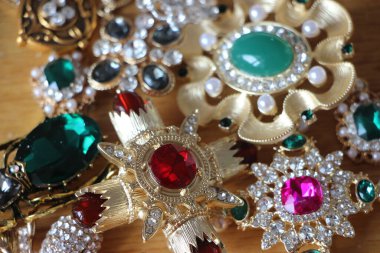 Zümrüt değerli taşlı klasik broşürler. Farklı renklerde cam ve metal broşlar. Renkli ve moda broşları. Lüks bir geçmişi var. Seçici odak