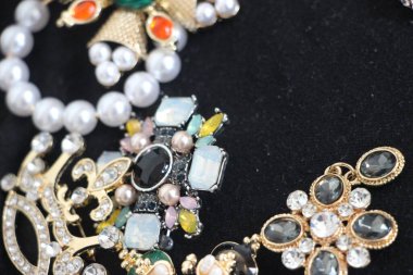 Zümrüt değerli taşlı klasik broşürler. Farklı renklerde cam ve metal broşlar. Renkli ve moda broşları. Lüks bir geçmişi var. Seçici odak