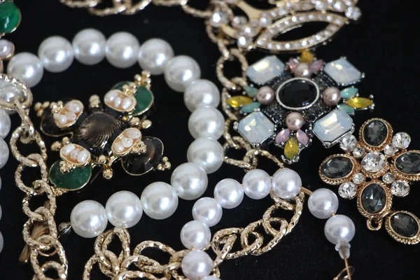 Zümrüt değerli taşlı klasik broşürler. Farklı renklerde cam ve metal broşlar. Renkli ve moda broşları. Lüks bir geçmişi var. Seçici odak