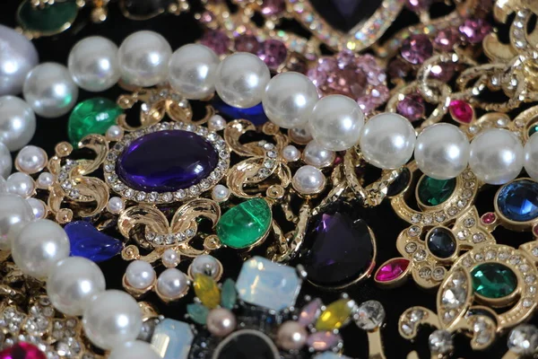 Zümrüt değerli taşlı klasik broşürler. Farklı renklerde cam ve metal broşlar. Renkli ve moda broşları. Lüks bir geçmişi var. Seçici odak