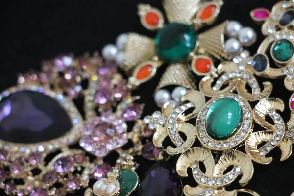 Zümrüt değerli taşlı klasik broşürler. Farklı renklerde cam ve metal broşlar. Renkli ve moda broşları. Lüks bir geçmişi var. Seçici odak