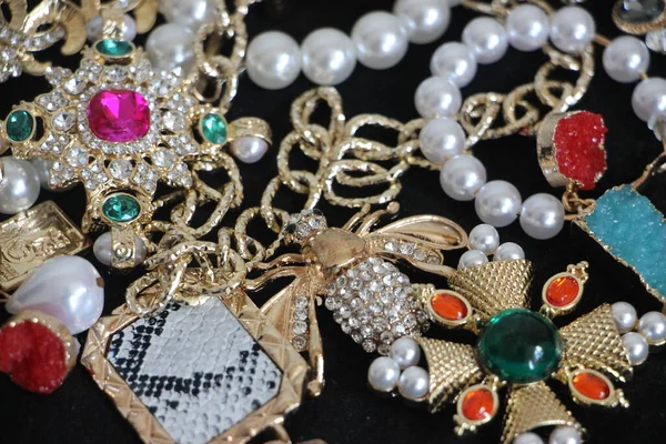 Zümrüt değerli taşlı klasik broşürler. Farklı renklerde cam ve metal broşlar. Renkli ve moda broşları. Lüks bir geçmişi var. Seçici odak