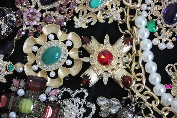 Zümrüt değerli taşlı klasik broşürler. Farklı renklerde cam ve metal broşlar. Renkli ve moda broşları. Lüks bir geçmişi var. Seçici odak