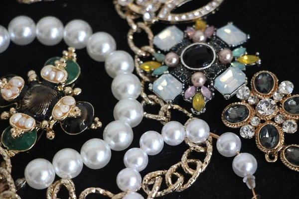 Zümrüt değerli taşlı klasik broşürler. Farklı renklerde cam ve metal broşlar. Renkli ve moda broşları. Lüks bir geçmişi var. Seçici odak