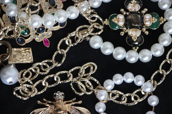 Zümrüt değerli taşlı klasik broşürler. Farklı renklerde cam ve metal broşlar. Renkli ve moda broşları. Lüks bir geçmişi var. Seçici odak