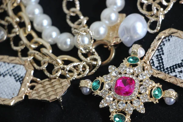 Zümrüt değerli taşlı klasik broşürler. Farklı renklerde cam ve metal broşlar. Renkli ve moda broşları. Lüks bir geçmişi var. Seçici odak