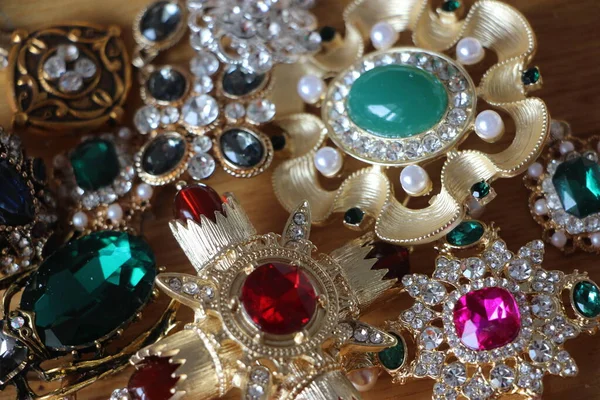 エメラルドの宝石でヴィンテージスタイルのブローチ 異なる色のガラスと金属の枝 カラフルでファッションブローチ 豪華な背景 選択的焦点 — ストック写真
