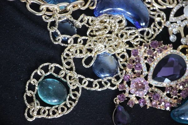 Zümrüt değerli taşlı klasik broşürler. Farklı renklerde cam ve metal broşlar. Renkli ve moda broşları. Lüks bir geçmişi var. Seçici odak