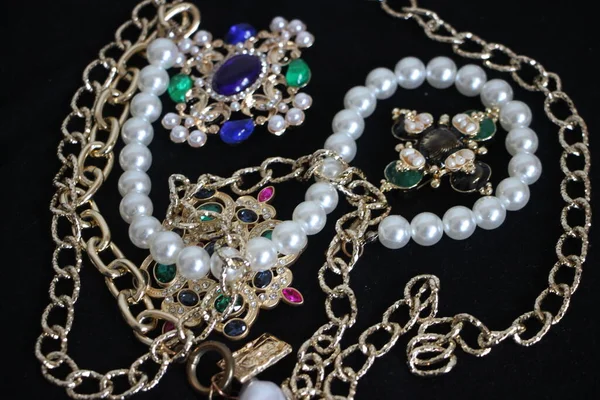 Zümrüt değerli taşlı klasik broşürler. Farklı renklerde cam ve metal broşlar. Renkli ve moda broşları. Lüks bir geçmişi var. Seçici odak