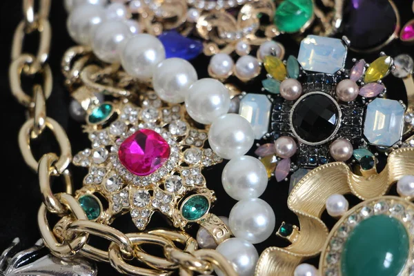 Zümrüt değerli taşlı klasik broşürler. Farklı renklerde cam ve metal broşlar. Renkli ve moda broşları. Lüks bir geçmişi var. Seçici odak