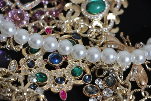 Zümrüt değerli taşlı klasik broşürler. Farklı renklerde cam ve metal broşlar. Renkli ve moda broşları. Lüks bir geçmişi var. Seçici odak