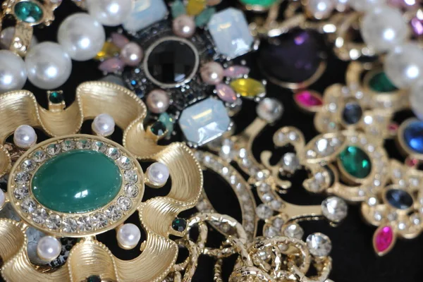 Zümrüt değerli taşlı klasik broşürler. Farklı renklerde cam ve metal broşlar. Renkli ve moda broşları. Lüks bir geçmişi var. Seçici odak