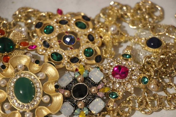 Zümrüt değerli taşlı klasik broşürler. Farklı renklerde cam ve metal broşlar. Renkli ve moda broşları. Lüks bir geçmişi var. Seçici odak