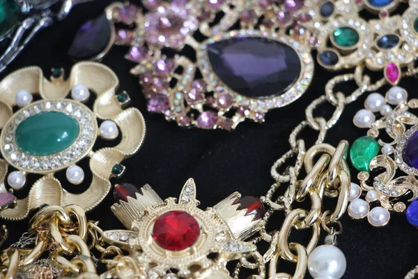 Zümrüt değerli taşlı klasik broşürler. Farklı renklerde cam ve metal broşlar. Renkli ve moda broşları. Lüks bir geçmişi var. Seçici odak