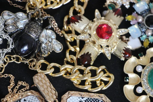 Zümrüt değerli taşlı klasik broşürler. Farklı renklerde cam ve metal broşlar. Renkli ve moda broşları. Lüks bir geçmişi var. Seçici odak