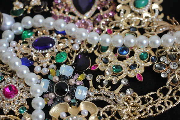 Zümrüt değerli taşlı klasik broşürler. Farklı renklerde cam ve metal broşlar. Renkli ve moda broşları. Lüks bir geçmişi var. Seçici odak