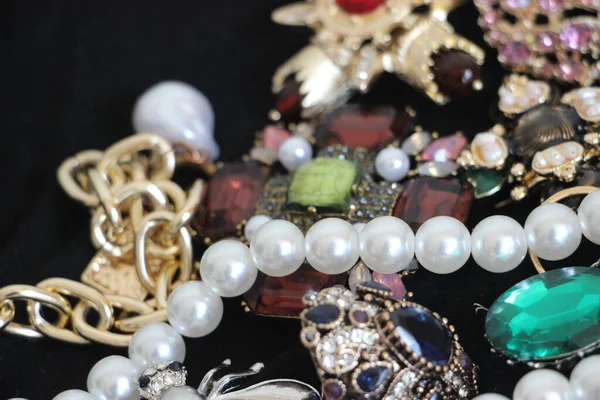 Zümrüt değerli taşlı klasik broşürler. Farklı renklerde cam ve metal broşlar. Renkli ve moda broşları. Lüks bir geçmişi var. Seçici odak