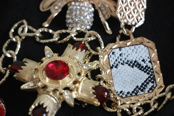 Zümrüt değerli taşlı klasik broşürler. Farklı renklerde cam ve metal broşlar. Renkli ve moda broşları. Lüks bir geçmişi var. Seçici odak