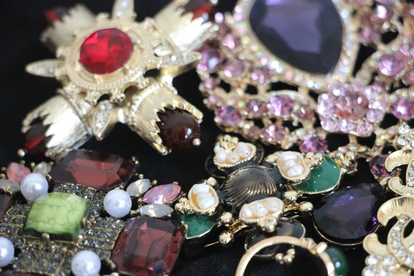 Zümrüt değerli taşlı klasik broşürler. Farklı renklerde cam ve metal broşlar. Renkli ve moda broşları. Lüks bir geçmişi var. Seçici odak