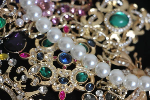 Zümrüt değerli taşlı klasik broşürler. Farklı renklerde cam ve metal broşlar. Renkli ve moda broşları. Lüks bir geçmişi var. Seçici odak