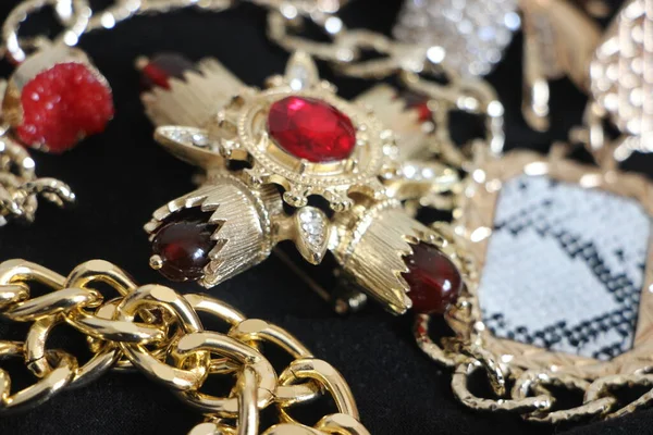 Zümrüt değerli taşlı klasik broşürler. Farklı renklerde cam ve metal broşlar. Renkli ve moda broşları. Lüks bir geçmişi var. Seçici odak