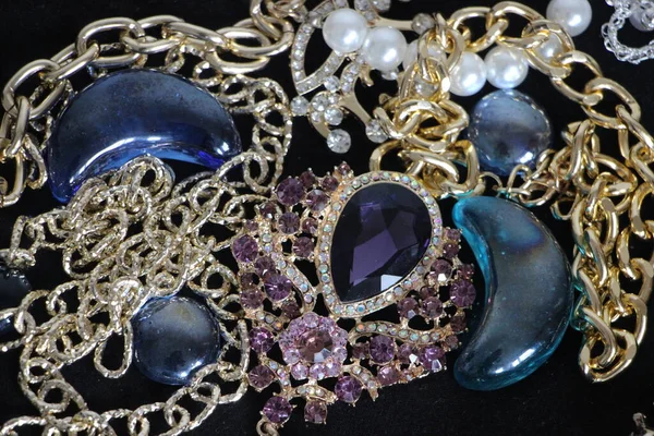 Zümrüt değerli taşlı klasik broşürler. Farklı renklerde cam ve metal broşlar. Renkli ve moda broşları. Lüks bir geçmişi var. Seçici odak