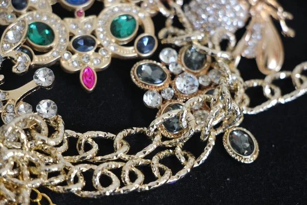 Zümrüt değerli taşlı klasik broşürler. Farklı renklerde cam ve metal broşlar. Renkli ve moda broşları. Lüks bir geçmişi var. Seçici odak