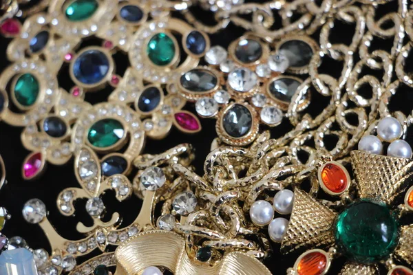 Zümrüt değerli taşlı klasik broşürler. Farklı renklerde cam ve metal broşlar. Renkli ve moda broşları. Lüks bir geçmişi var. Seçici odak