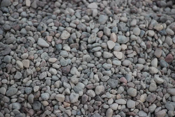 pebbles close up view, grey natural irregular stones texture industrial style background