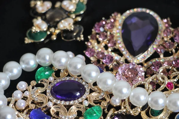 Zümrüt değerli taşlı klasik broşürler. Farklı renklerde cam ve metal broşlar. Renkli ve moda broşları. Lüks bir geçmişi var. Seçici odak