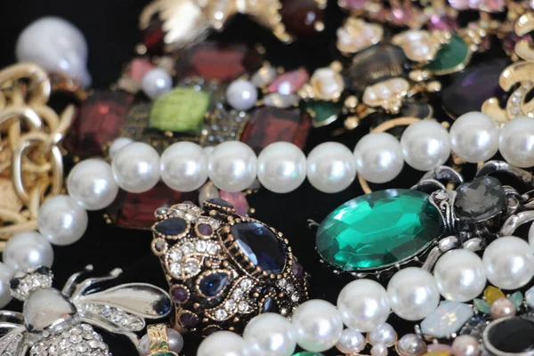 Zümrüt değerli taşlı klasik broşürler. Farklı renklerde cam ve metal broşlar. Renkli ve moda broşları. Lüks bir geçmişi var. Seçici odak