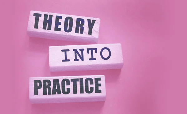 Theory into practice words written on wooden blocks. Education or business startup concept