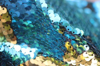 Yanıp sönen ışıklarla birlikte soyut parıltı dokusu. Mavi ve altın arkaplanlı kumaş pullar.