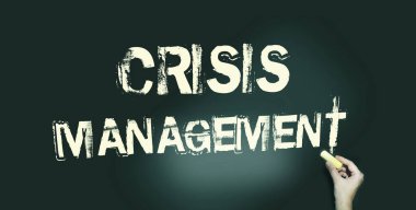 Kara tebeşirle yazılmış Kriz Yönetimi kelimesi. Tebeşirle yazılmış. Tahtada açık sarı yazı var. Risk yönetimi iş konsepti