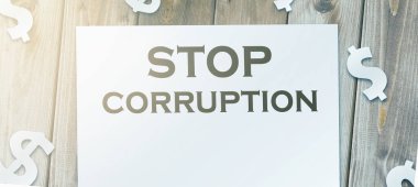 Sayfadaki Yolsuzluk Sözcükleri 'ni ve ahşap masadaki kağıt para işaretlerini durdurun. Yolsuzlukla mücadele konsepti