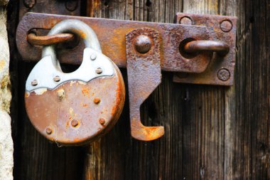 Kilitli eski kapıya asma kilit asılıyor