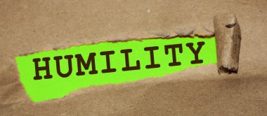 Alçakgönüllülük sözcüğüyle yırtılmış kağıt parçaları. Sosyal konsept.