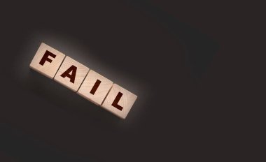 Başarısız Kelime metni siyah arkaplan üzerine tahta küp bloklarıyla yazılmış. İş krizi kavramı.