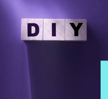 Ahşap küp bloklar ve kırmızı arka planda DIY harfleri. Kopyalama alanı ile iş kavramı