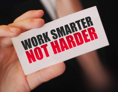İş adamı üzerinde motivasyon mesajı yazan bir kart tutuyor. Daha akıllı ol, daha akıllı değil.
