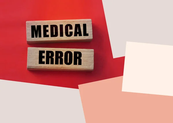 Medical error text on wooden blocks on red. Healthcare concept.
