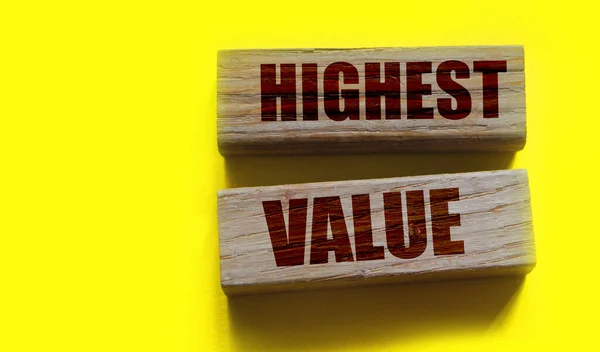 Highest values words on wooden building blocks isolated on yellow. Social, business and education concept