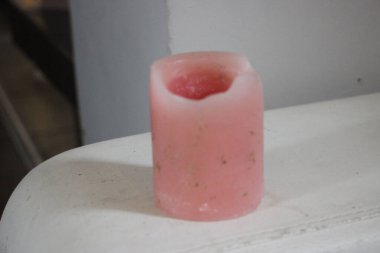 Beyaz arka planda kırmızı saplı cam şişe.