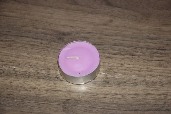 Ahşap bir masada pembe mum