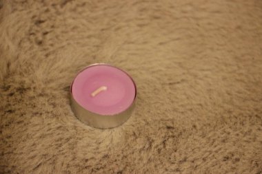 Beyaz arka planda cam bir kavanozda pembe mum.