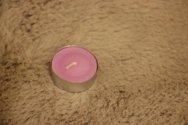 Beyaz arka planda cam bir kavanozda pembe mum.